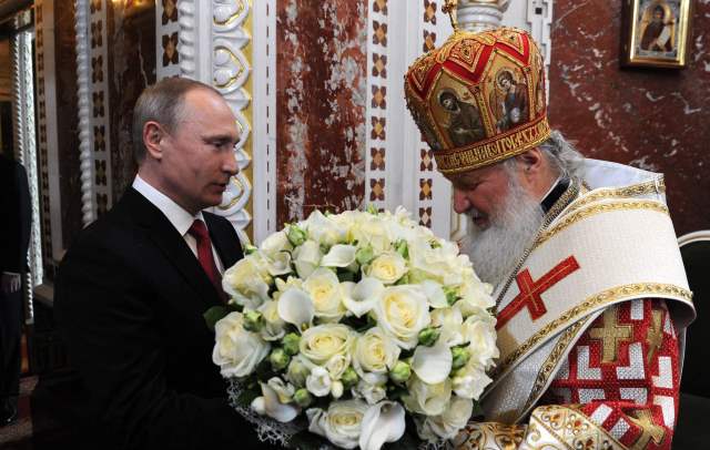 Путин дарит цветы патриарху
